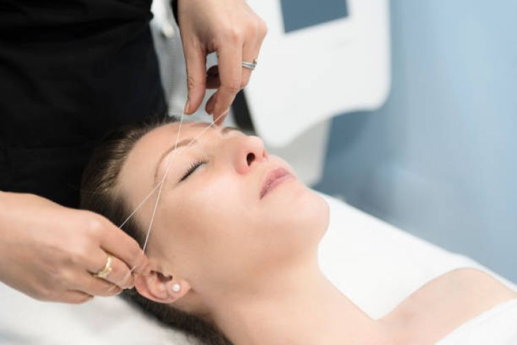 woman removing facial hair with Threading