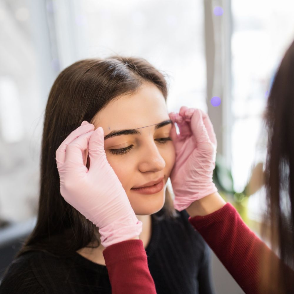 master checks the contour of the eyebrows with thread